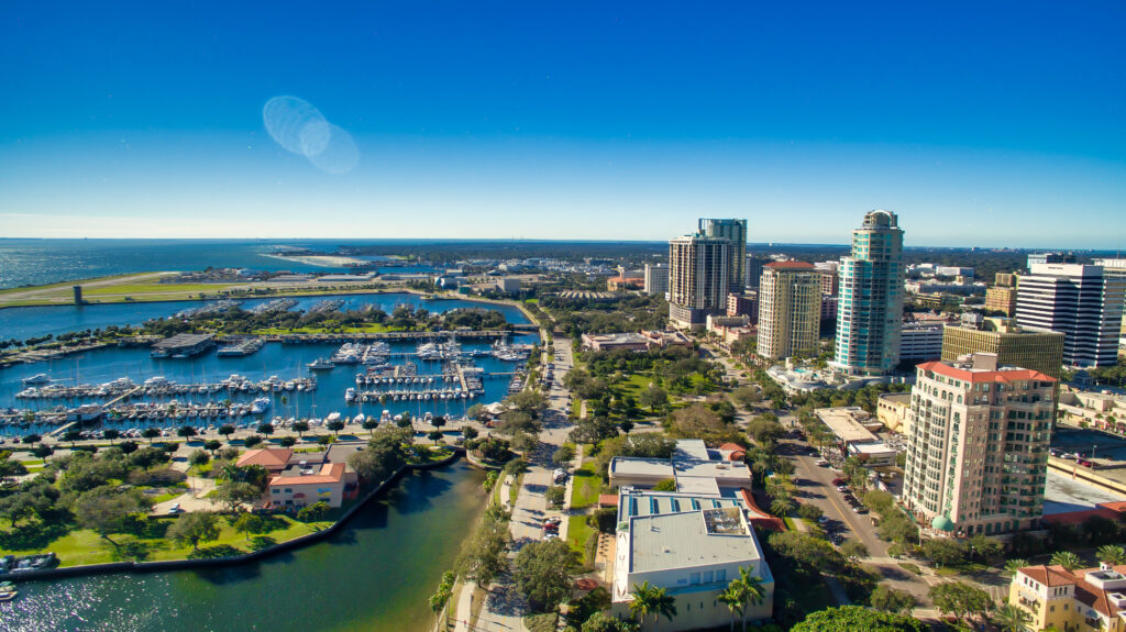 Aerial view of downtown St. Petersburg, Florida, showcasing the marina, waterfront, and city skyline under a clear blue sky. This vibrant urban setting is perfect for events organized by UDREAM EVENTS.