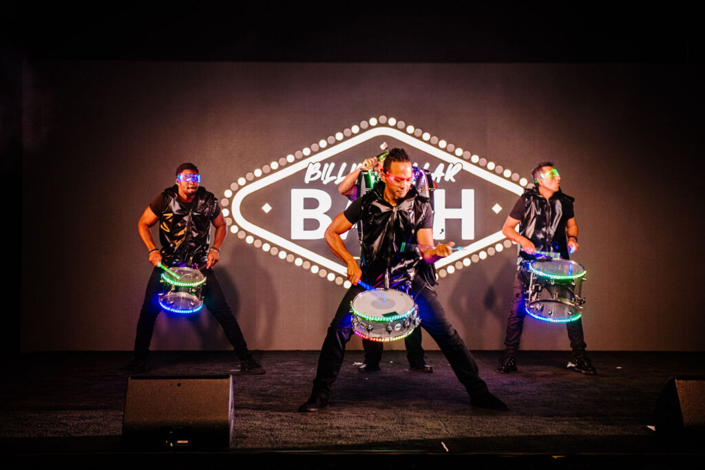 Dynamic drum performance at the Billion Dollar Bash, featuring drummers with illuminated drums, adding excitement to the event entertainment.