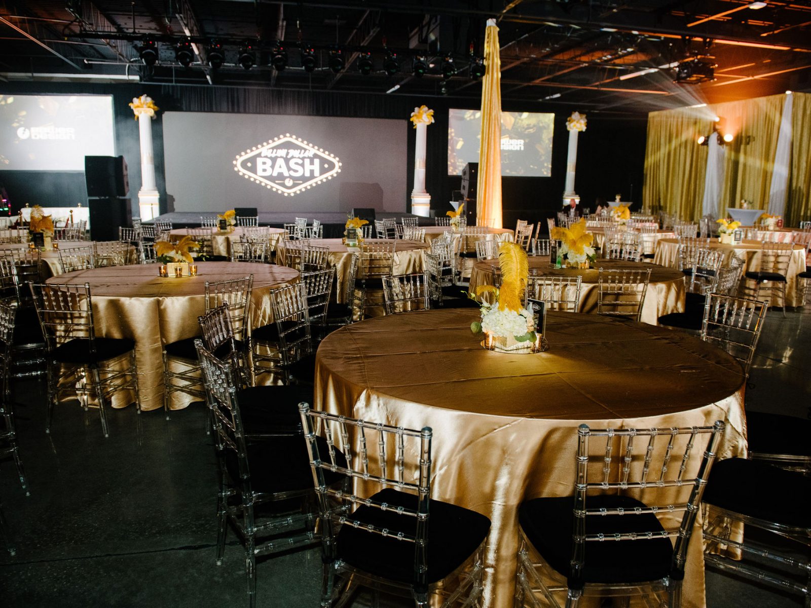 Beautifully decorated banquet hall with round tables, gold tablecloths, and black chairs, set up for a grand corporate event or gala in Tampa Bay.