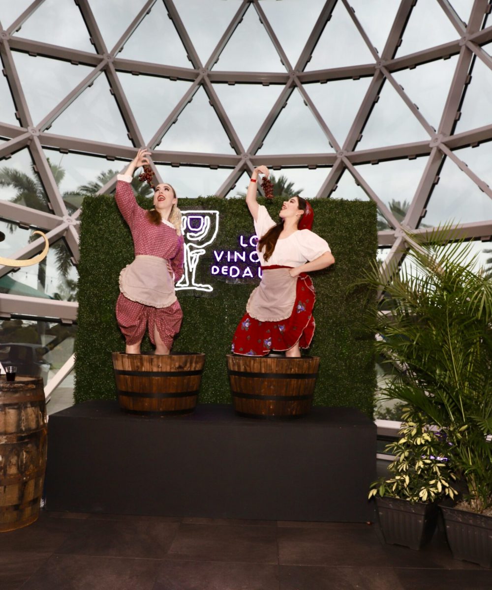 Participants enthusiastically grape stomping in barrels at a unique wine-themed event in Florida, surrounded by rustic decor.