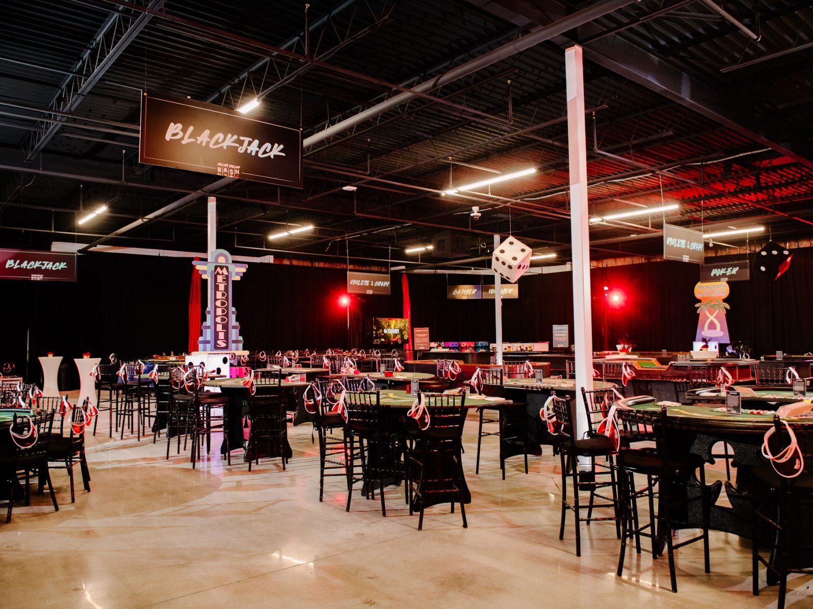 Casino-themed party setup with blackjack tables and large dice decorations, perfect for a lively corporate event or fundraiser in Florida.